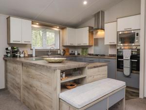 eine Küche mit weißen Schränken und einer Holzarbeitsplatte in der Unterkunft Fountain View in Carnforth