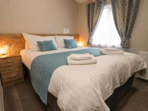 een slaapkamer met een groot bed en handdoeken bij Fountain View in Carnforth