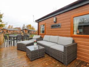 eine Terrasse mit Korbmöbeln auf einer Holzterrasse in der Unterkunft Fountain View in Carnforth