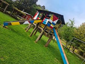a playground with colorful equipment on the grass at Camping y cabañas Los Parrones in Valdivia