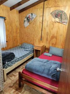 a bedroom with two beds and a table with an umbrella at Camping y cabañas Los Parrones in Valdivia +39 photos