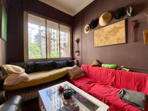 a living room with a red couch and a window at El Santuario - Domitorio privado - Cool Depto compartido in Buenos Aires