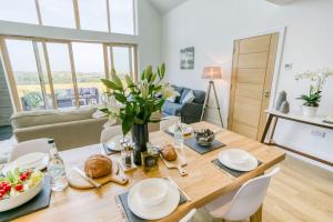 a dining room with a wooden table with food on it at Bwncath & Hebog in Llanrhwydrys