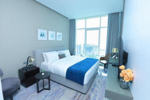 ein Schlafzimmer mit einem großen Bett und einem großen Fenster in der Unterkunft Damac Maison Prive Deluxe Studio with Burj-khalifa view in Dubai