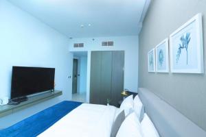 a bedroom with a bed and a flat screen tv at Damac Maison Prive Deluxe Studio with Burj-khalifa view in Dubai