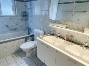 La salle de bains est pourvue de 2 lavabos, de toilettes et d'une baignoire. dans l'établissement Schöne grosse Attika-Wohnung im Zentrum von Vaduz inkl. Parkplatz, à Vaduz