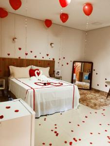 um quarto com balões vermelhos na parede e uma cama em HOTEL PLAZA PONTES e LACERDA em Pontes e Lacerda