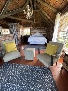 Un dormitorio con una cama y dos sillas y una lámpara de araña. en Hemel in Hermanus, en Hermanus 33 fotos más