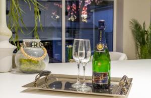 a bottle of champagne and two glasses on a sink at Festival Villa and City Villa in Edinburgh