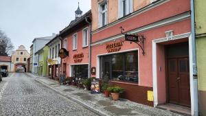 una strada con negozi ed edifici su una strada di ciottoli di Apartament ANGELO a Głogówek