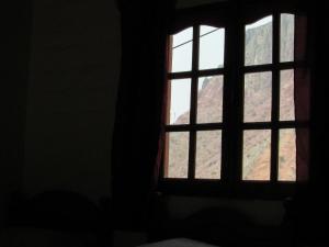 a window in a dark room looking out at a mountain at El mirador de iruya in Iruya