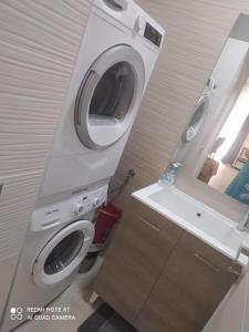 a bathroom with a washing machine and a sink at CASETTA DEL SARACENO in Roccalumera