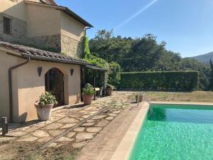 een huis met een zwembad naast een huis bij Casa Batano in San Casciano dei Bagni