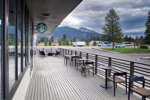 a balcony with tables and chairs and a clock on a building at Marmot Lodge Jasper in Jasper +4 photos