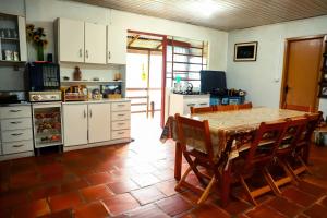 eine Küche mit einem Tisch und Stühlen im Zimmer in der Unterkunft Caminhos de Caravaggio - Hostel Parada dos Caminhantes in Nova Palmira