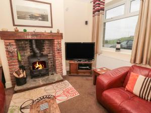 a living room with a fireplace and a television at Seascape in Morpeth