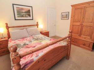 a bedroom with a wooden bed and two night stands at Seascape in Morpeth