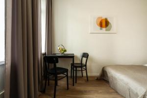 um quarto com uma mesa e duas cadeiras ao lado de uma cama em Air Apartment 112 em Vilnius