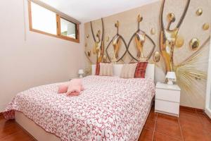 a bedroom with a bed with a pink pillow on it at Golden Sunny View Apartment in Puerto Rico de Gran Canaria