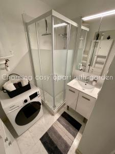 a white bathroom with a shower and a sink at Charming cosy apart with garden free parking in Claye-Souilly