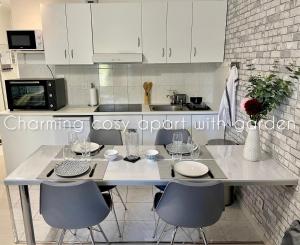a kitchen with a table with chairs and a counter top at Charming cosy apart with garden free parking in Claye-Souilly
