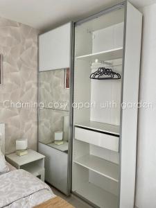 a bedroom with a glass closet with shelves at Charming cosy apart with garden free parking in Claye-Souilly
