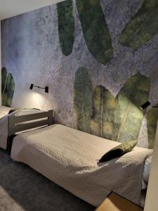 - une chambre avec 2 lits et une fresque murale dans l'établissement Luxury Copper Apartment, à Łódź