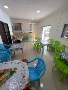 a dining room with tables and chairs and a kitchen at hotel Brazza in Brazzaville