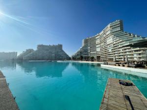 a large swimming pool next to two large buildings at San Alfonso Mágico - Vista Panorámica - Laguna y Playa Privada in Algarrobo