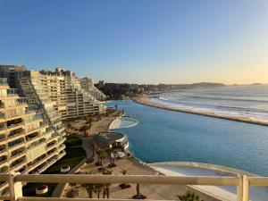 a view of a beach with buildings and the ocean at San Alfonso Mágico in Algarrobo