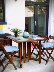 a wooden table with chairs and a tea kettle on it at Duplex cosy - entre lacs et montagnes - Fêtes interdites in Fillinges