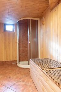 y baño con ducha en una pared de madera. en Velika planina Chalet SLOVENKA en Stahovica
