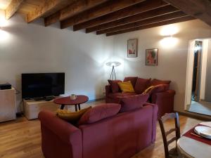 Tignac的住宿－La Treille，客厅配有两张沙发和一台电视机