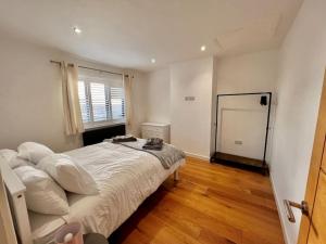 um quarto com uma cama com lençóis brancos e uma janela em Stylish 3 bed house with Castle views em Lincolnshire