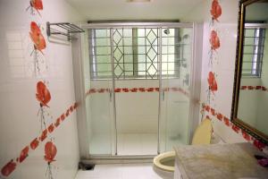 a bathroom with a shower with red flowers on the wall at Ali International Hotel in Dhaka