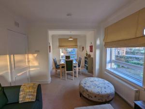 sala de estar con sofá verde y mesa en Two bed flat in a quiet village near Stirling en Bridge of Allan