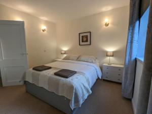 Two bed flat in a quiet village near Stirling في بريدج أف آلان: غرفة نوم مع سرير كبير مع مصباحين
