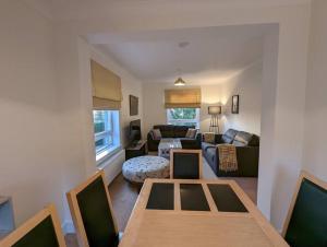 een woonkamer met een tafel en een bank bij Two bed flat in a quiet village near Stirling in Bridge of Allan