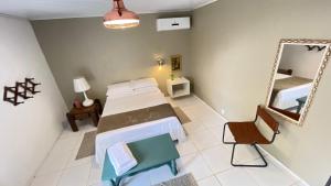 una camera con letto e specchio di Acasarosa Hostel a Praia Grande