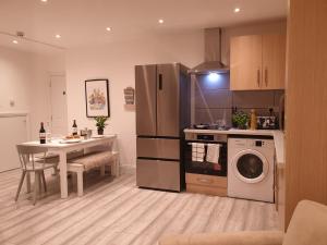 a kitchen with a table and a refrigerator at New - Spacious London 1 bedroom king bed apartment in quiet street near parks 1072gar in London
