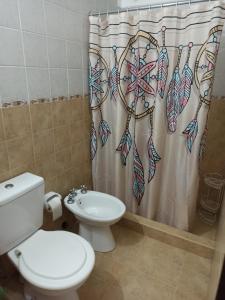 y baño con aseo y cortina de ducha. en Departamento 2 Ambientes en Edificio Céntrico en Resistencia