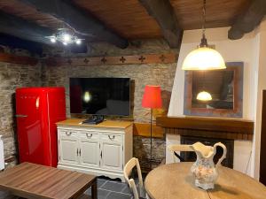 cocina con mesa y nevera roja en Casas Rurales TAReira en Taramundi en Taramundi