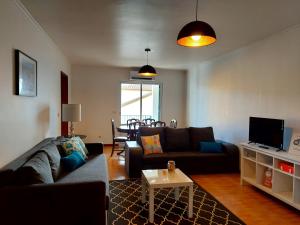 een woonkamer met een bank en een tafel bij Beach & Surf in Ribeira Grande