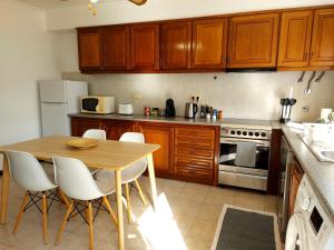 uma cozinha com uma mesa de madeira e electrodomésticos brancos em Beach & Surf em Ribeira Grande
