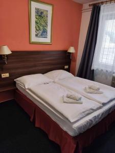 a bedroom with a large bed with two towels on it at Hotel Formanka in Hustopeče