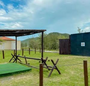 a field with a wooden fence and a shed at Hotel Búzios Resort com Entretenimento in Búzios
