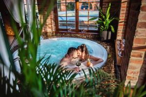 un hombre y una mujer en una bañera en Żabi Dwór - HOTEL - RESTAURACJA - SPA, en Zielona Góra