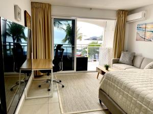 a bedroom with a bed and a desk and a couch at Maho Beach Escape Luxe Studio Condo next to The Morgan Village in Maho Reef