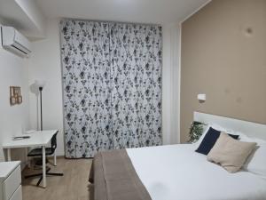 a bedroom with a white bed and a desk at Civico 29 apartment in Messina +11 photos