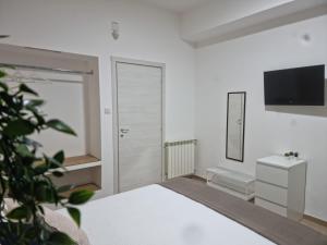 Habitación blanca con cama y TV en Civico 29 apartment en Messina